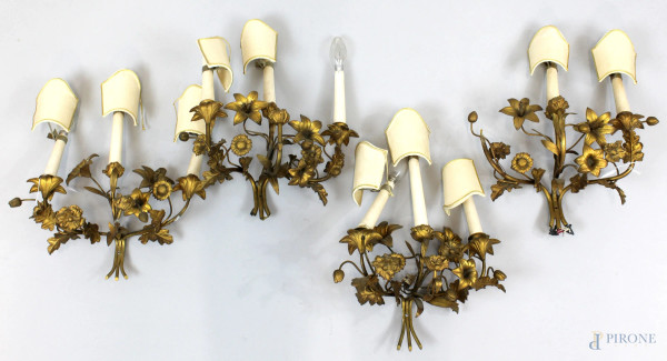 Quattro appliques in metallo dorato a tre luci, decori a fiori e foglie, altezza cm 40