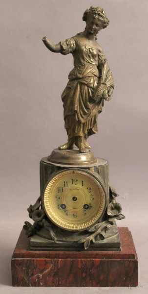 Orologio in bronzo sormontato da figura, base in marmo rosso, H 46 cm, difetti.