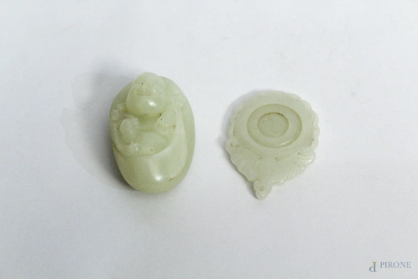 Lotto composto da un ciondolo in giada con simbolo taoista e da un ciondolo in giada con budda a rilievo, Cina XX sec., H massima 5,5 cm.