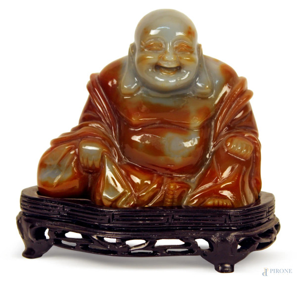 Scultura in corniola, raffigurante Budda, poggiante su base in legno, H. 9,5 cm.,Cina XX sec.