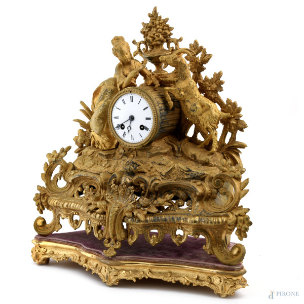 Orologio in antimonio dorato con quadrante a smalto e numeri romani. Sculture apicali di dama con...