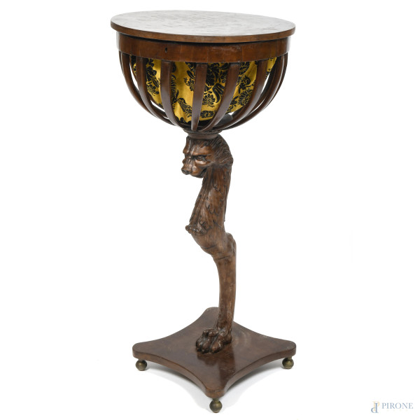 Tavolino da lavoro in legno intagliato con fusto a guisa di animale mitologico. Piano apribile contenente vano in tessuto, XX secolo, cm 86,5x40, (segni di usura, scalfiture, fessurazioni, rotture, restauri, difetti, fori di tarlo)