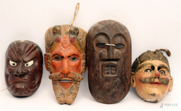 Lotto composto da quattro antiche maschere in legno a soggetti diversi.