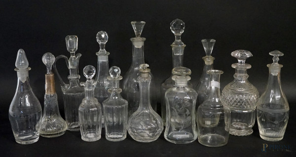 Lotto di quattordici ampolle e piccoli versatoi in vetro e cristallo controtagliato, alt.max cm 25,5,  XX secolo, (difetti e mancante un tappo).