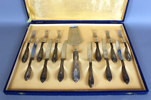 Servizio da dolce in metallo con manici in argento composto da: una paletta, sei forchettine e sei coltelli, entro custodia.