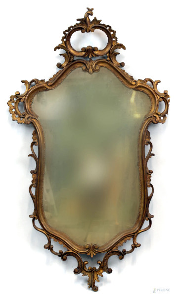 Specchiera in legno dorato ed intagliato,  cimasa e decori a motivi di volute vegetali, XIX secolo, cm h 120x71, (difetti).