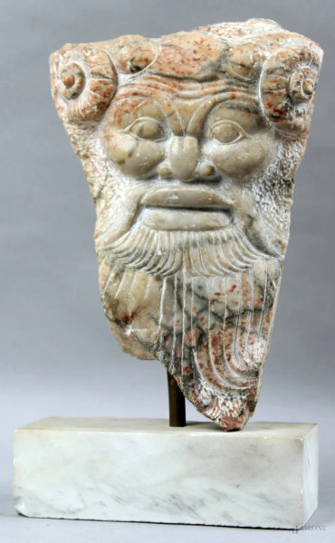 Riproduzione in marmo di frammento raffigurate mascherone, base in marmo, h. 30 cm, senza base.