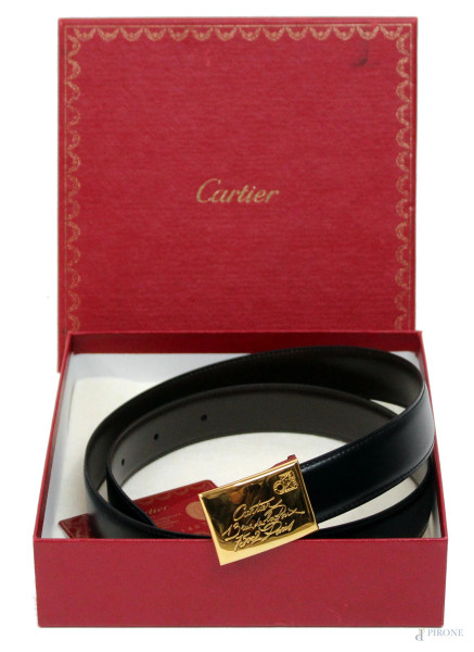 Cartier, cintura nera in cuoio con fibbia dorata incisa, collezione Must de Cartier, lunghezza cm 103, entro scatola originale completa di garanzia.