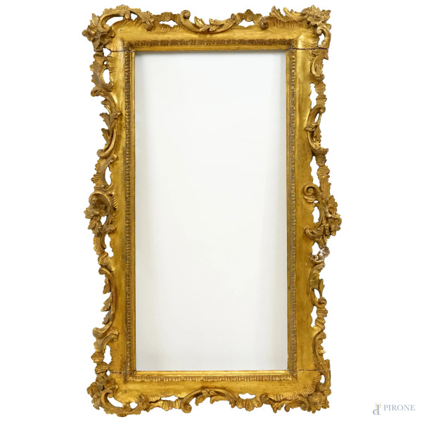 Cornice in legno intagliato e dorato, inizi XX secolo, con decori scolpiti a foglie, volute e fiori, misure ingombro cm 58x98, luce cm 36,5x76, (difetti).