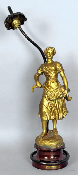 Lampada in antimonio dorato sorretta da figura, altezza 51 cm.