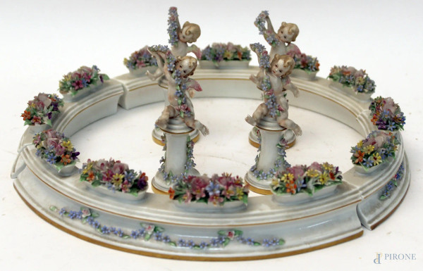 Giardiniera in porcellana policroma con fiori a rilievo, composto da quattro pezzi, accompagnato da quattro puttini, H massima 11,5 cm, piccoli difetti.