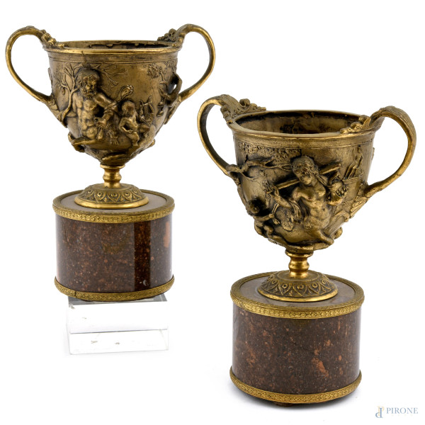 Coppia di coppe in bronzo cesellato con scene mitologiche a rilievo su base in marmo, XX secolo, altezza massima cm 22, (segni di usura)