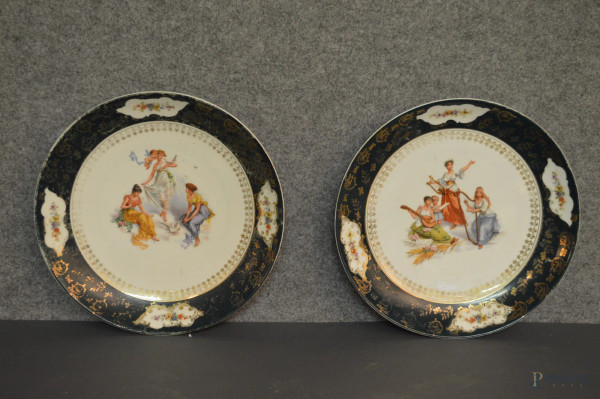 Coppia piatti in porcellana a decoro policromo con medaglioni centrali a scene di fanciulle e particolari dorati su fondo verde, diam,30 cm.