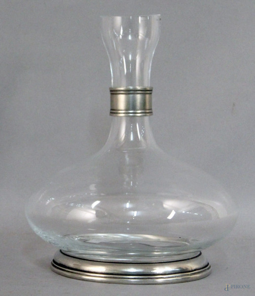 Decanter in vetro poggiante su base in metallo, altezza 22 cm.