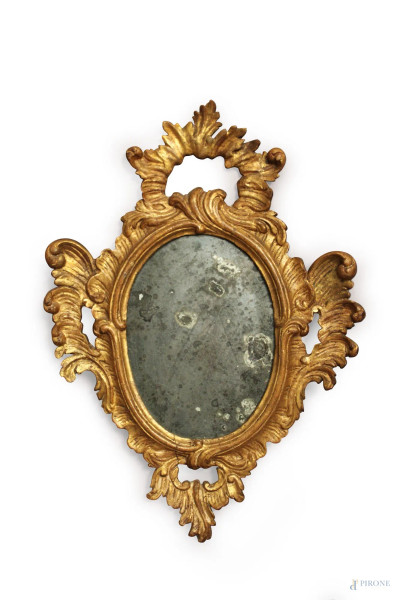 Piccola specchiera ovale in legno intagliato e dorato a motivi di foglie d&#39;acanto, specchio a mercurio, XVIII sec., cm 54 x 39.