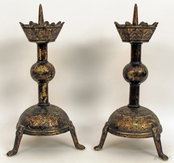 Coppia di candelieri in bronzo poggianti su tre gambe con volti leonini, H 35 cm.