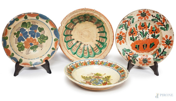 Lotto di quattro piatti in terracotta con decori dipinti a motivi floreali, diam.max cm 23, XIX secolo, (difetti).