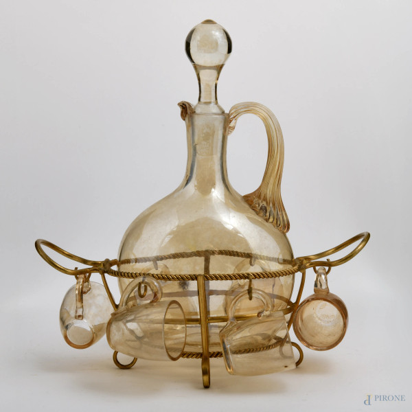 Servizio  da liquore in vetro nei toni del giallo, composto da bottiglia e sei bicchierini. Base in metallo dorato, XX secolo, cm 25x23x11, (difetti)