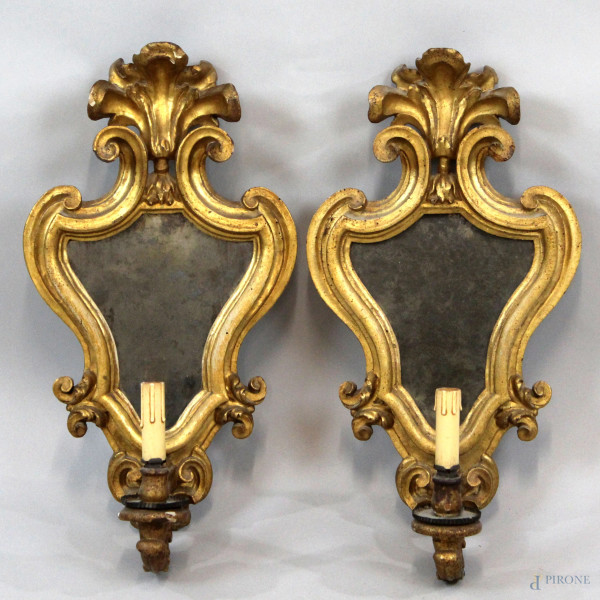 Coppia di appliques a specchio in legno intagliato e dorato a motivo di volute, XIX secolo, altezza cm 55, (difetti).