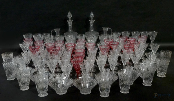 Servizio di bicchieri in cristallo controtagliato  color rosso rubino e trasparente, XX secolo, composto da: 2 bottiglie, 2 versatoi, 10 bicchieri da acqua, 17 bicchieri da vino rosso, 40 bicchieri da vino bianco, 18 bicchierini e altri 15 bicchierini da liquore, 9 bicchierini da amaro, 11 coppette da macedonia, (servizio incompleto)