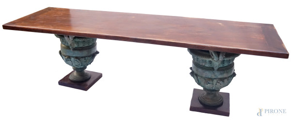 Tavolo in noce, XX secolo, lungo piano rettangolare poggiante su coppia di vasi in ghisa, cm h 80x280x90, (difetti).
