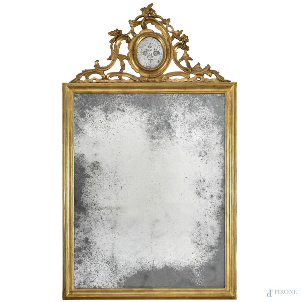 Specchiera in legno dorato, elemento apicale intagliato con inserto specchiato a serto ovale, XIX secolo, cm 112x64, (segni di usura, scalfiture, rotture, difetti)