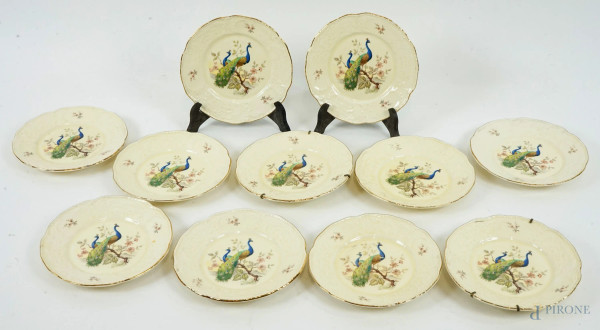 Undici piattini in porcellana color crema, con cavetti a decoro di pavoni su rami, diam. cm 17, marcati Imperial Crwon Ivory Stone sotto la base, (lievi difetti).