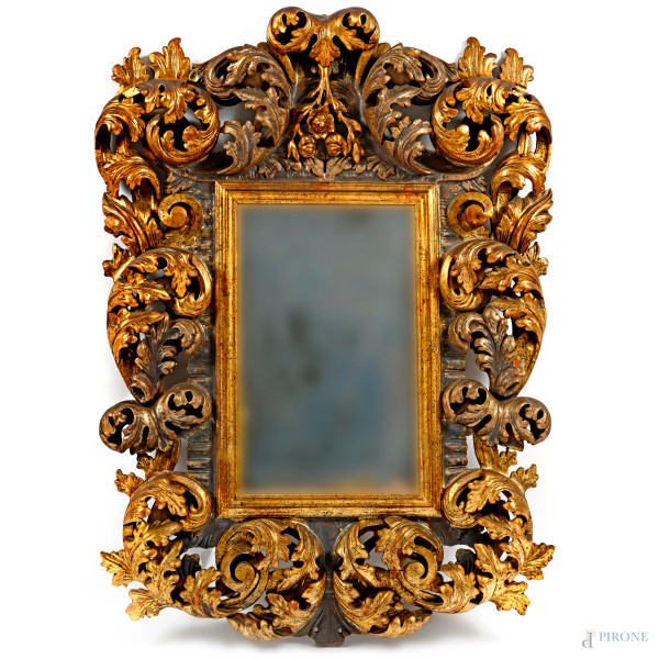 Specchiera con cornice in legno dorato e intagliato a volute fogliacee, XX secolo, cm 134x95, (difetti)