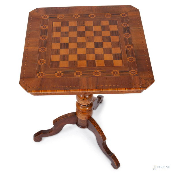 Tavolinetto in varie essenze con piano ottagonale ad intarsi a scacchiera. Tre piedi mossi e fust...