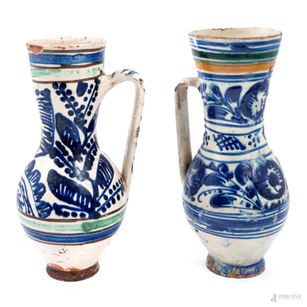 Coppia di vasi monoansati in maiolica decorata nei toni del blu, XIX secolo, altezza massima cm 23,5, (segni di usura, scalfiture, cadute di smalto, rotture, restauri, difetti)