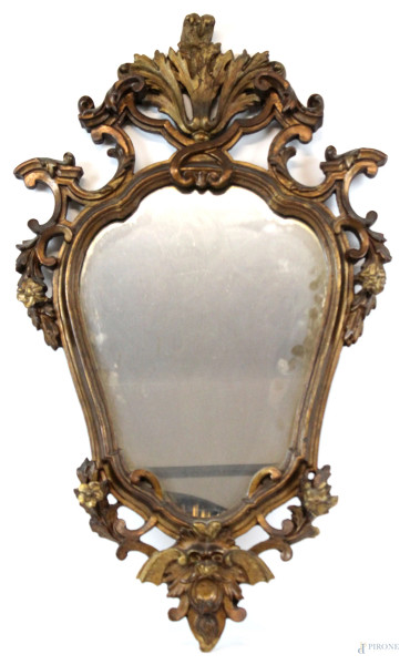 Specchiera di linea sagomata in legno intagliato e dorato, inizi XX secolo, cm h 77, (difetti e restauri).