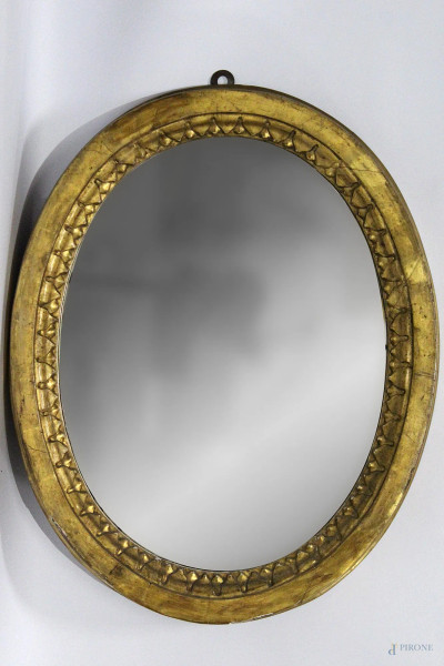 Piccola specchiera ovale in legno intagliato e dorato, inizi XIX sec, h 56x45 cm.