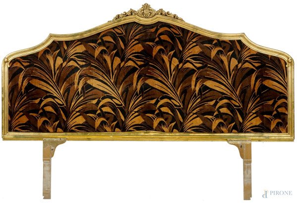 Testata da letto in legno intagliato e dorato, XX secolo, con cornice sagomata a volute, tappezzeria in velluto, cm 83x176 (esclusi montanti), (difetti, parti rotte)