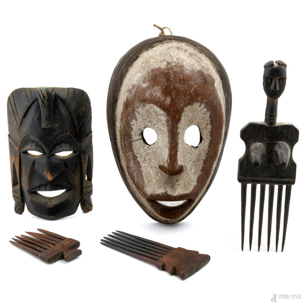 Lotto composto da due maschere e tre pettini africani in legno, XX secolo, misure massime cm 29x19,5, (segni di usura del tempo)