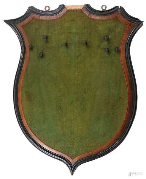 Scudo porta trofei, in legno intagliato e dipinto, profilo ebanizzato, cm 171x138, XX secolo, (difetti).