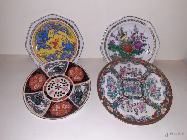 Lotto di quattro piattini diversi da muro in porcellana orientale a decori policromi, marcati,(difetti), diam. 18 cm.