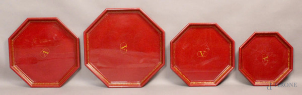 Lotto composto da quattro vassoi di linea ottagonale in legno laccato rosso con decori di fiori, cm. 40x9.