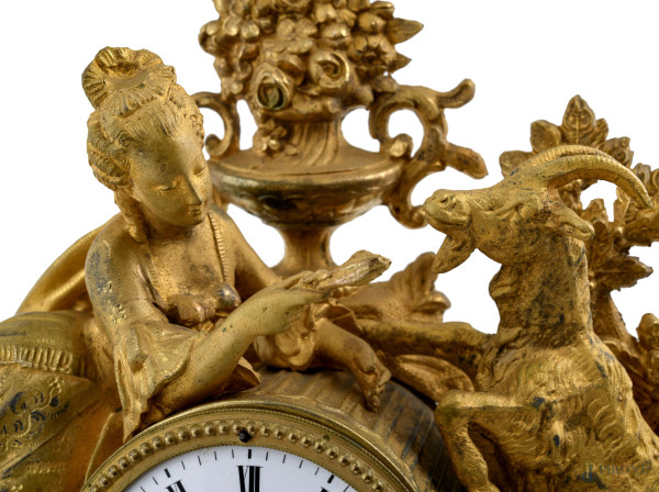 Orologio in antimonio dorato con quadrante a smalto e numeri romani. Sculture apicali di dama con...