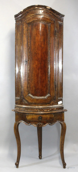 Angoliera bombata del XVIII secolo, in legno tinto a noce, un'anta pannellata con cappello modanato aggettante, gambe mosse, cm h 196x43x43, (restauri, difetti)
