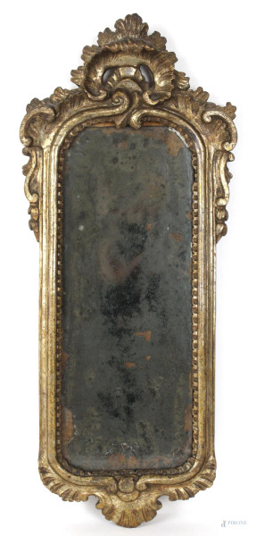 Specchiera in legno intagliato e dorato, cornice e cimasa scolpite a motivi vegetali, cm 63x27, XVIII secolo