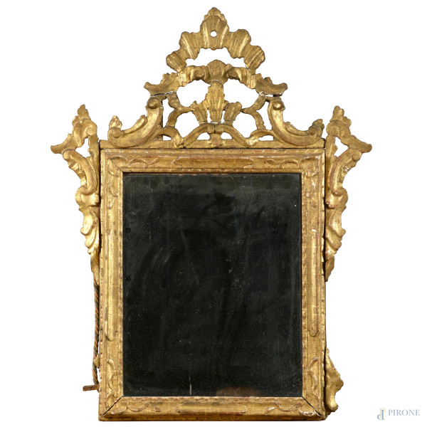 Specchiera in legno intagliato e dorato con elemento apicale a volute, XIX-XX secolo, cm 78x61, (segni di usura, perdite di doratura, scalfiture, rotture, mancanze, difetti)