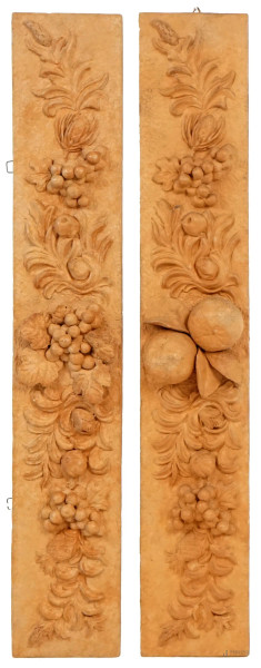 Coppia di fregi in terracotta con decoro ad altorilievo a grappoli d'uva, limoni e foglie, cm 71,5x12,5, XX secolo, (difetti).