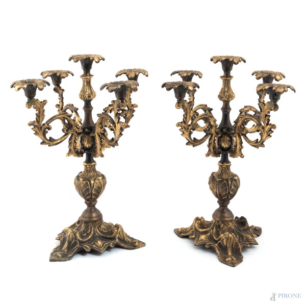 Coppia di candelabri a cinque luci  in bronzo cesellato a volute, altezza cm 36,5, (segni di usura, difetti)