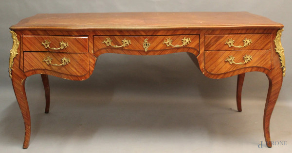 Scrivania di linea Luigi XV di linea rettangolare centinata in satinwood, a cinque cassetti con guarnizioni in bronzo, h 80x170x76 cm, XX sec, (difetti).