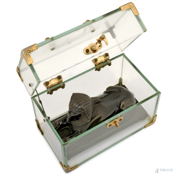 Scultura in metallo brunito su base rettangolare, inserita all'interno di teca in plexiglass con ...