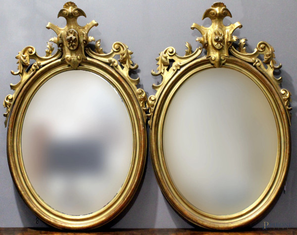 Coppia di specchiere ovali in legno intagliato e dorato, fine XIX secolo, cm 114x75