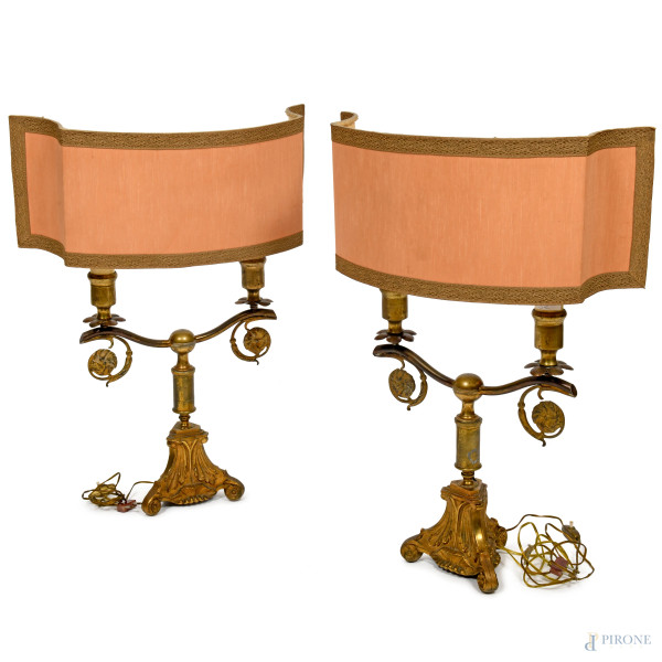 Coppia di lampade da tavola in bronzo dorato e cesellato a due bracci con base a capitello e tre piedini a ricciolo. Diffusori in tessuto color salmone. XIX-XX secolo, cm 43,5x35x18, (da revisionare)