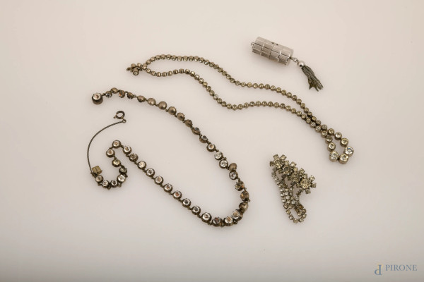 Lotto composto da 2 collane in metallo argentato e strass, 1 spilla in metallo argentato e strass e 1 orologio a ciondolo in metallo argento (difetti e meccanismo da revisionare), misura dell'orologio cm 3x1,5