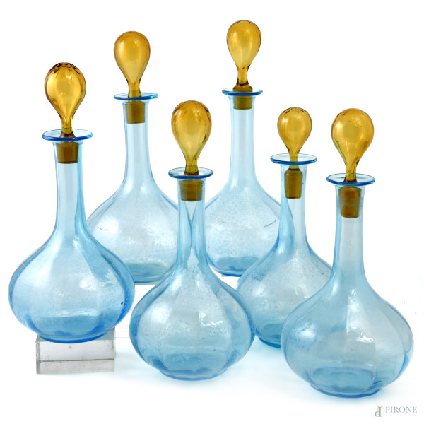 Lotto di sei bottiglie in vetro nei toni dell'azzurro e del giallo, XX secolo, altezza cm 24, (tappi non pertinenti, segni di usura, graffi, sbeccature)