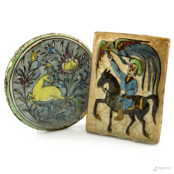 Lotto di due mattonelle decorate con scene di falconeria e animali, fine del XIX secolo, misure massime cm 22x16, (segni di usura, scalfiture, difetti)